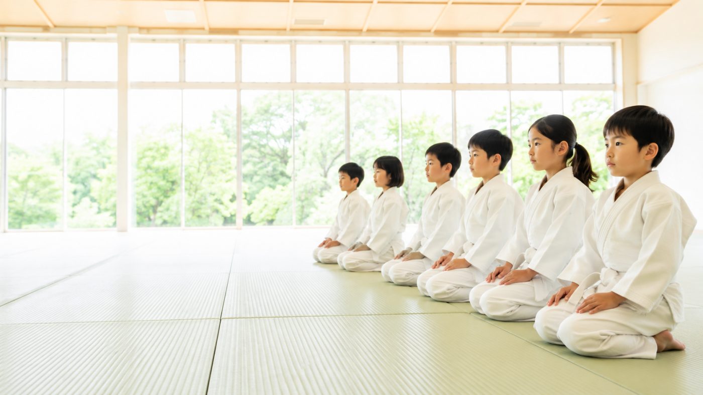 道場で正座して前を見つめる子どもたち